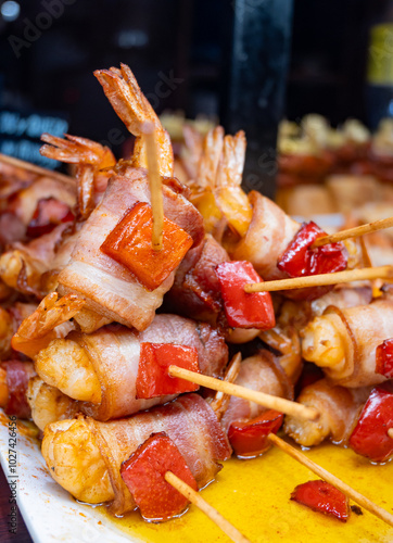 Typical snacks of Basque Country, pinchos or pinxtos skewers with small pieces of bread, fish, sea food, sweet green pepper served in bar in San-Sebastian or Bilbao, Spain photo