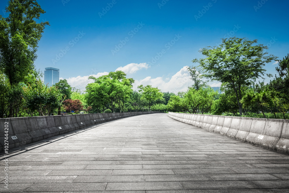 Tranquil Urban Pathway Surrounded by Lush Greenery Under a Bright Sky Tranquil Urban Pathway Surrounded by Lush Greenery Under a Bright Sky