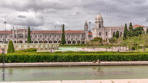 Empire Square timelapse hyperlapse (Praca do Imperio in Portuguese), city square and park adjacent to the Jeronimos Monastery in parish of Belem. Green garden with pond and fountain. Lisbon, Portugal photo