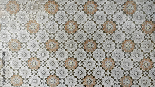 Delicate Floral Crochet Pattern: A close-up of a vintage crocheted tablecloth featuring a delicate floral pattern in cream and brown hues.