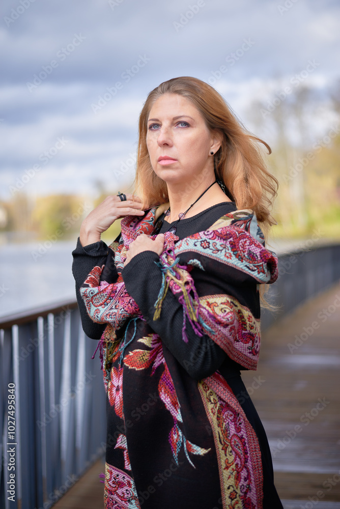 Beautiful woman in black dress and necklace walking in autumn forest. Relaxation concept Beautiful woman in black dress and necklace walking in autumn forest. Relaxation concept