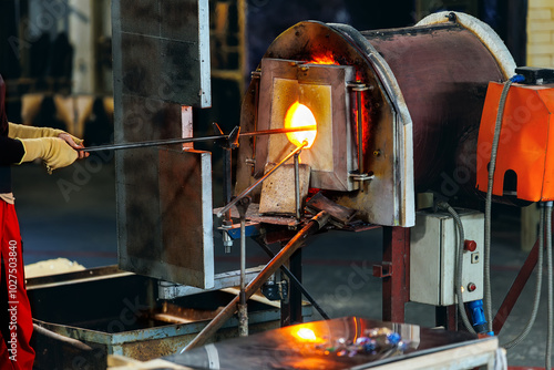 Tablou pe pânză Close-up glassblowing process tube tool with molten glass shaped inside refractory furnace in industrial craft workshop