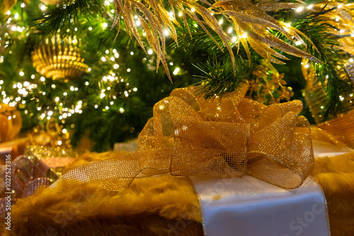 Gift wrappred presents under Christmas tree with gold glittery ribbon. Festice decorations. Graphic resource. Background. photo