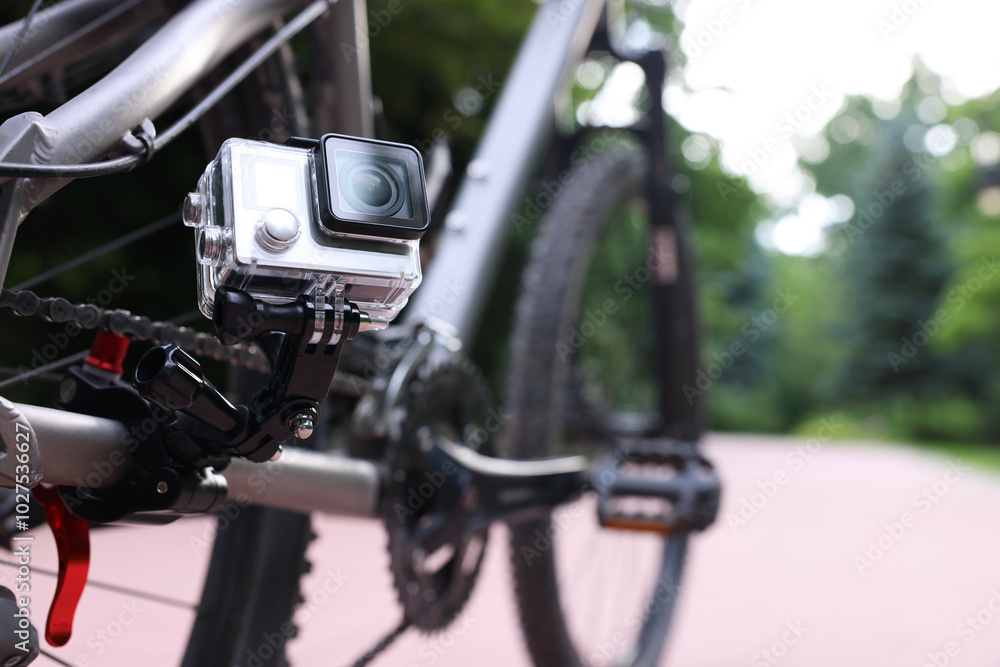 Modern action camera with mount on bicycle outdoors, closeup. Space for text Modern action camera with mount on bicycle outdoors, closeup. Space for text