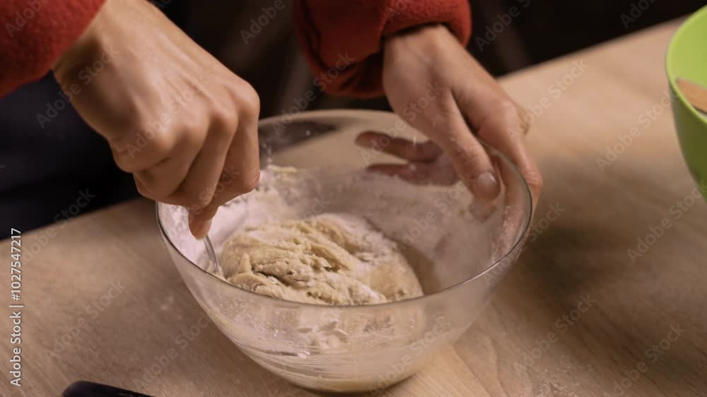 Woman mixing cookie dough in glass bowl during Christmas baking Woman mixing cookie dough in glass bowl during Christmas baking