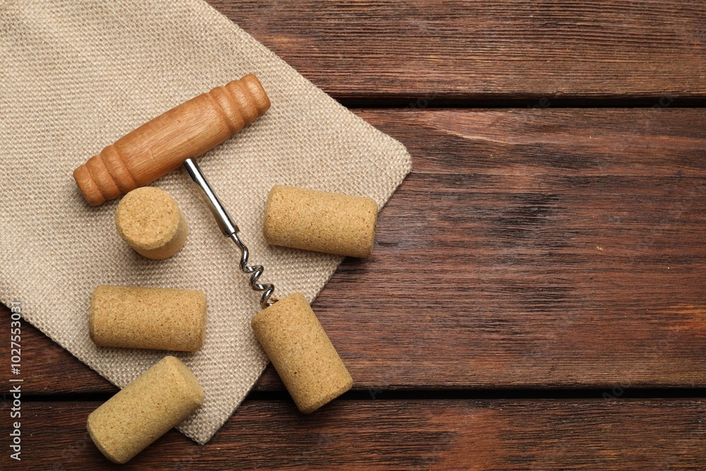 Corkscrew and corks on wooden table, flat lay. Space for text Corkscrew and corks on wooden table, flat lay. Space for text