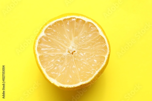 Fresh lemon half on yellow background, top view