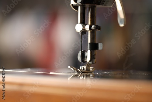 Sewing machine with thread on blurred background, macro view