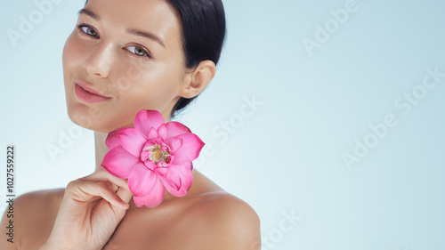 Elegant Woman with Pink Lotus Flower for Natural Beauty and Skincare Theme photo