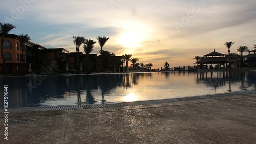 Dramatic morning sky with the sun rays crossing the clouds. Harmony of seclusion and meditation near the beautiful sea waves. The golden or blue hour of the sunrise or sunset. Hotel resort Egypt.	