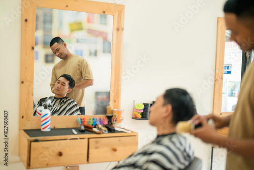 A man is currently having his hair cut by a skilled barber inside a local barber shop, where they focus on grooming and hairstyling