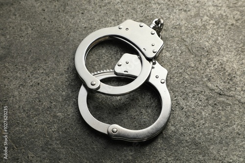 Classic chain handcuffs on grey table, closeup photo