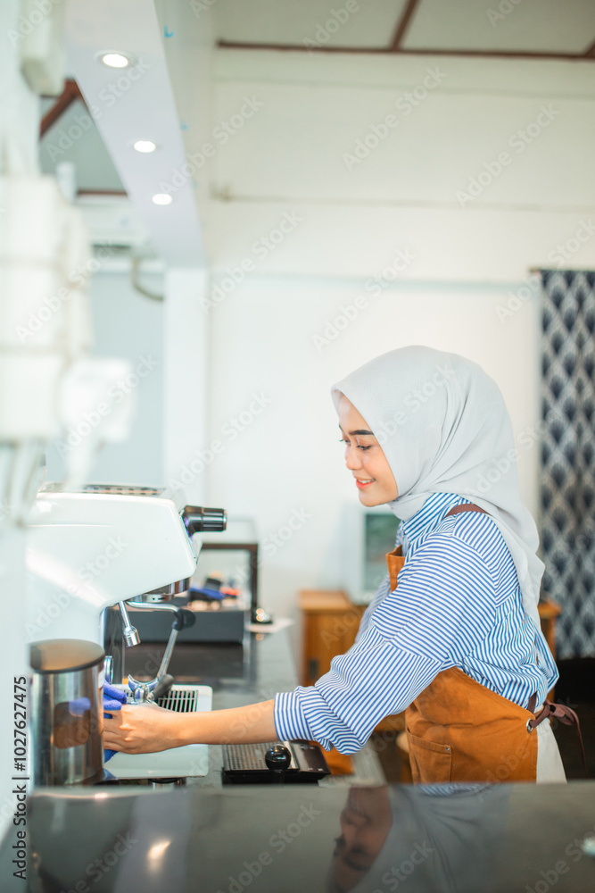 Asian veiled woman cafe owner cleaning drip coffee maker at cafe Asian veiled woman cafe owner cleaning drip coffee maker at cafe