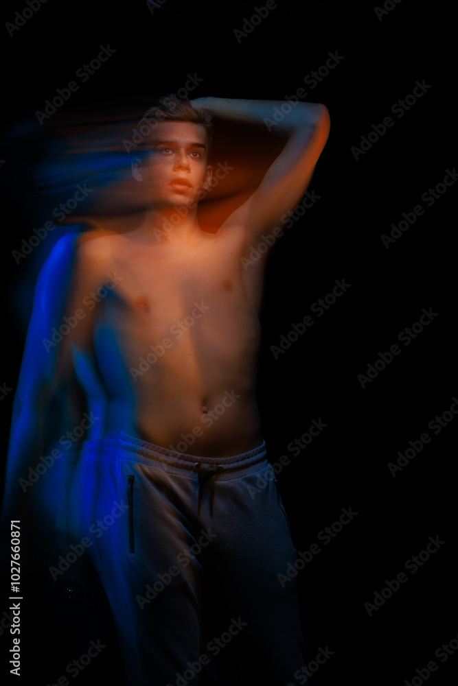 Naklejka premium blurred silhouette, young man posing in the dark with red and blue light in the studio