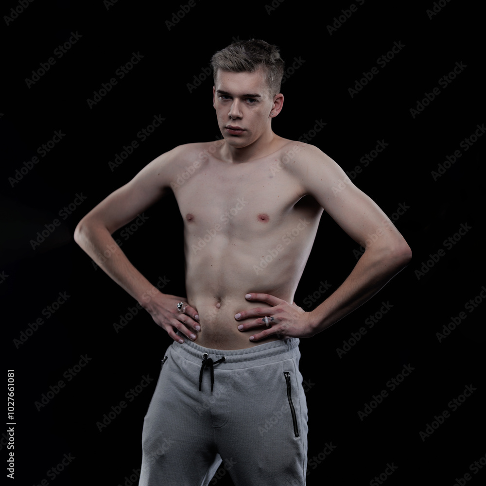Young man posing in the dark in the studio Young man posing in the dark in the studio