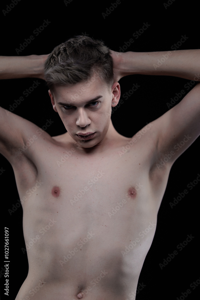Young man posing in the dark in the studio Young man posing in the dark in the studio