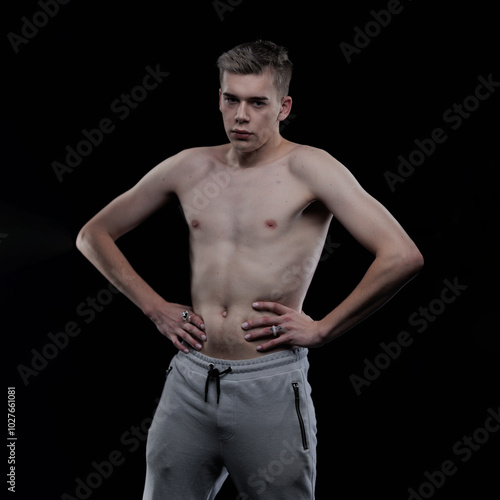 Young man posing in the dark in the studio