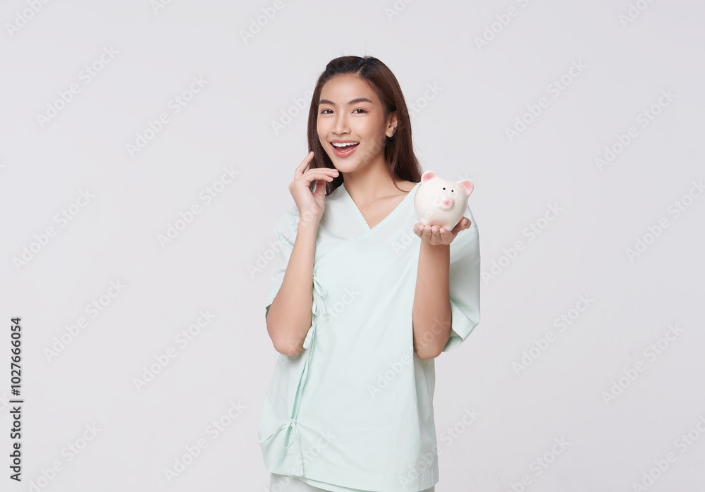 Happy Asian young female patients holding piggy bank in hand. To pay medical expenses financial health check-up or saving for medical insurance costs isolated on white background.. Happy Asian young female patients holding piggy bank in hand. To pay medical expenses financial health check-up or saving for medical insurance costs isolated on white background..