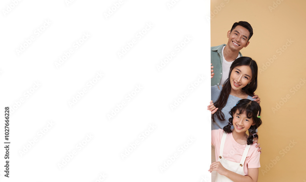 portrait Happy asian family with empty banner for advertising isolated on nude color background. portrait Happy asian family with empty banner for advertising isolated on nude color background.