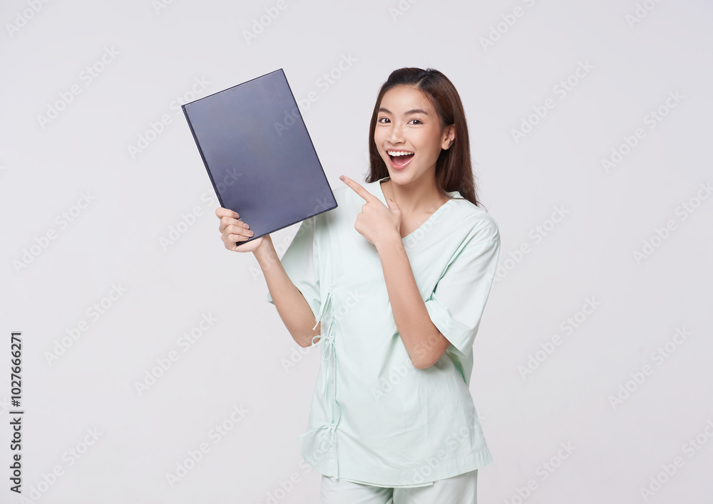 Happy Asian woman wearing patient outfits showing insurance policy for assurance in life with a smiling face isolated on white background. death benefit insurance concept. Happy Asian woman wearing patient outfits showing insurance policy for assurance in life with a smiling face isolated on white background. death benefit insurance concept.