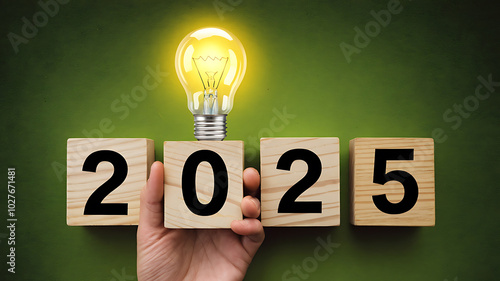 A glowing lightbulb illuminates wooden blocks spelling 2025, symbolizing new ideas and opportunities for the new year. 
