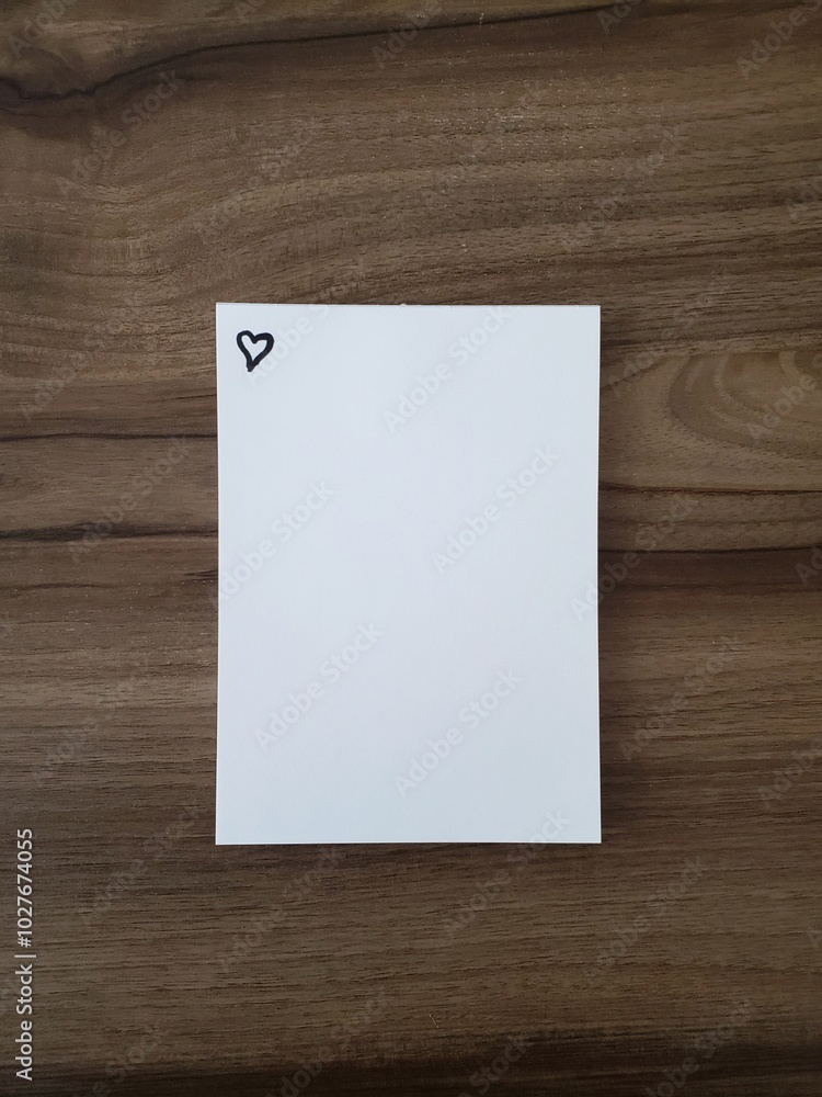 notepad over a wooden table with a heart in the right upper corner notepad over a wooden table with a heart in the right upper corner