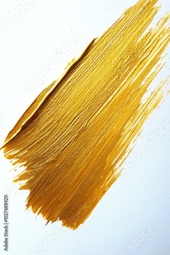 Golden paint stroke on white canvas showcasing creativity and artistic expres...