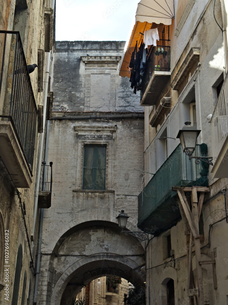 Narrow street in the old town center. Architecture of historic tenement houses in the Italian city. Bari, Puglia, Italy. Narrow street in the old town center. Architecture of historic tenement houses in the Italian city. Bari, Puglia, Italy.