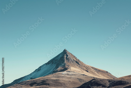 A solitary mountain peak against a clear blue sky