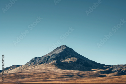 A solitary mountain peak against a clear blue sky