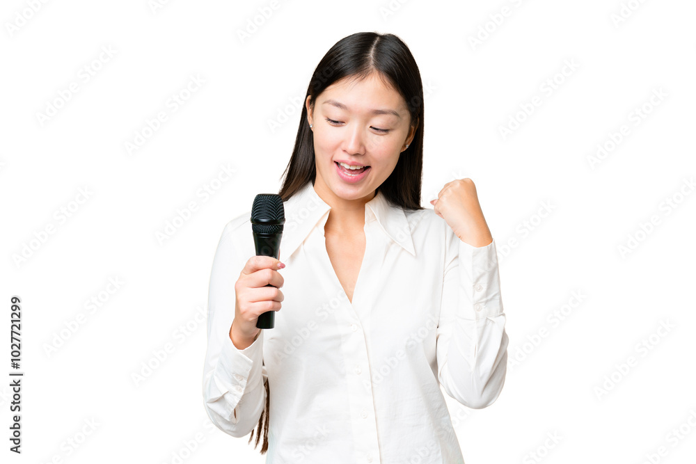 Singer picking up a microphone over isolated chroma key background celebrating a victory Singer picking up a microphone over isolated chroma key background celebrating a victory
