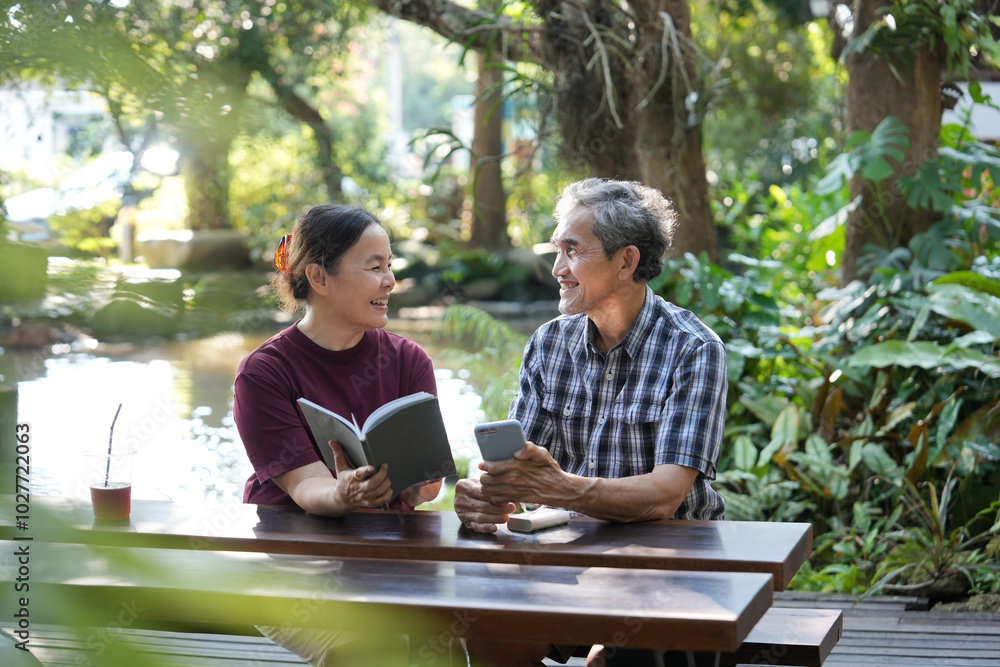 asian senior married couple spend hobbies time reading and surfing internet with smartphone together in the garden,elderly lifestyle,relaxing asian senior married couple spend hobbies time reading and surfing internet with smartphone together in the garden,elderly lifestyle,relaxing