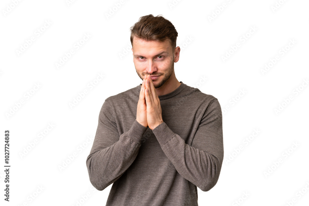 Young handsome caucasian man over isolated chroma key background keeps palm together. Person asks for something Young handsome caucasian man over isolated chroma key background keeps palm together. Person asks for something