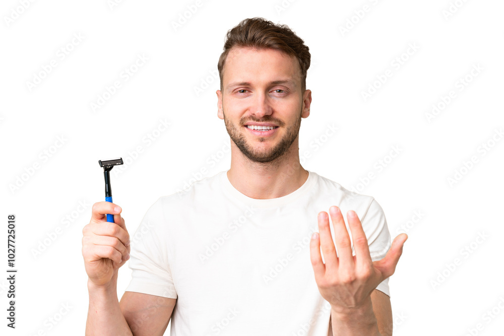Young caucasian man shaving his beard over isolated chroma key background inviting to come with hand. Happy that you came Young caucasian man shaving his beard over isolated chroma key background inviting to come with hand. Happy that you came