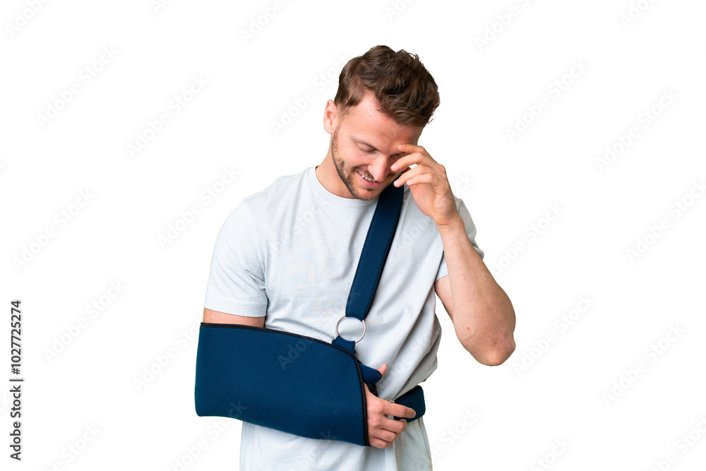 Young caucasian man with broken arm and wearing a sling over isolated chroma key background laughing Young caucasian man with broken arm and wearing a sling over isolated chroma key background laughing