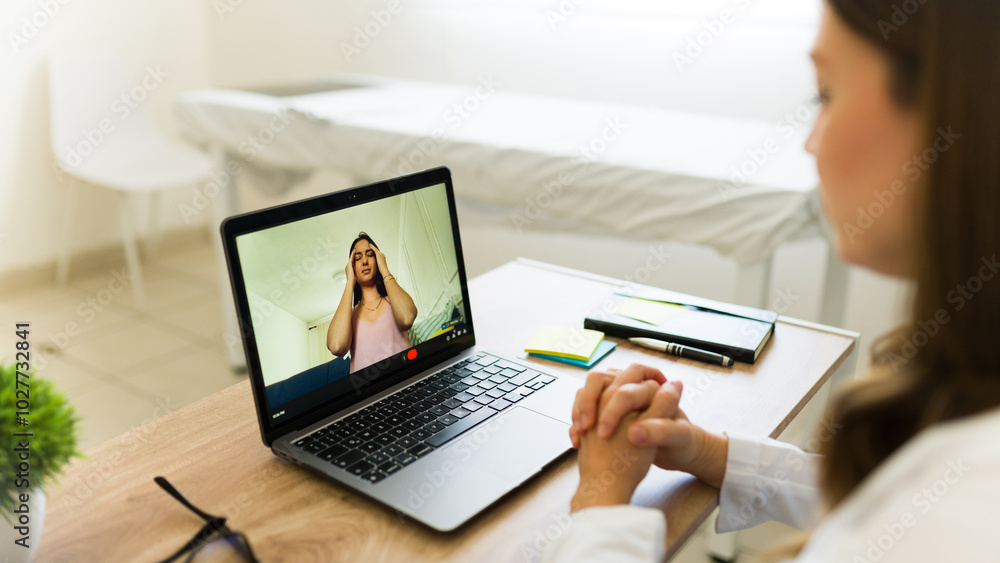 Doctor is having a video call with her patient who is describing her symptoms Doctor is having a video call with her patient who is describing her symptoms