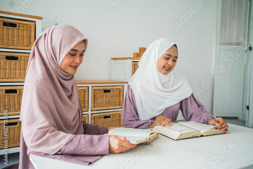 In a cozy setting, two hijabwearing women study together, sharing knowledge collaboratively photo