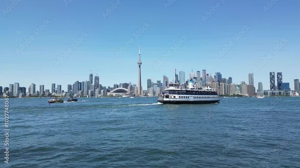 Ferry sailing toward downtown Toronto waterfront skyline view from Centre Island showing the city shoreline including the famous CN tower Ferry sailing toward downtown Toronto waterfront skyline view from Centre Island showing the city shoreline including the famous CN tower