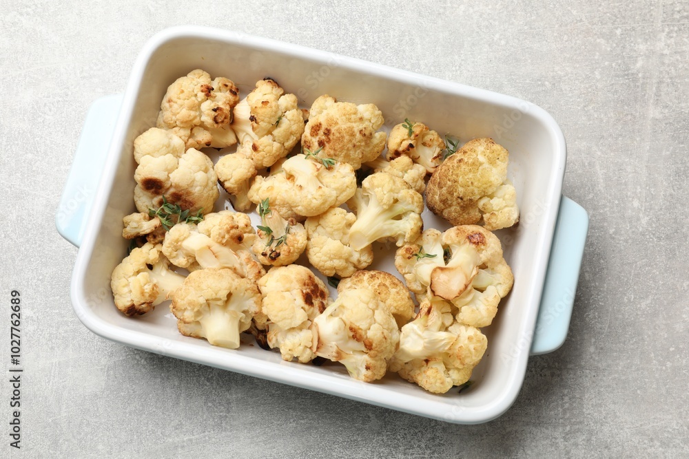 Baked cauliflower in baking dish on light grey table, top view Baked cauliflower in baking dish on light grey table, top view