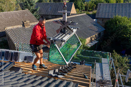 Ein Dach wird neu gedeckt. Unterkonstruktion mit Weichfaserplatten, Dachlatten, Beton-Dachsteine in der Farbe Anthrazit, Dachziegel, Ortgang