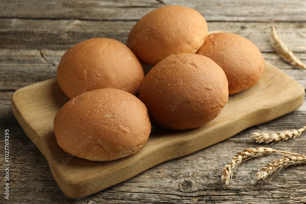 Fresh tasty buns and spikes on wooden table, closeup Fresh tasty buns and spikes on wooden table, closeup