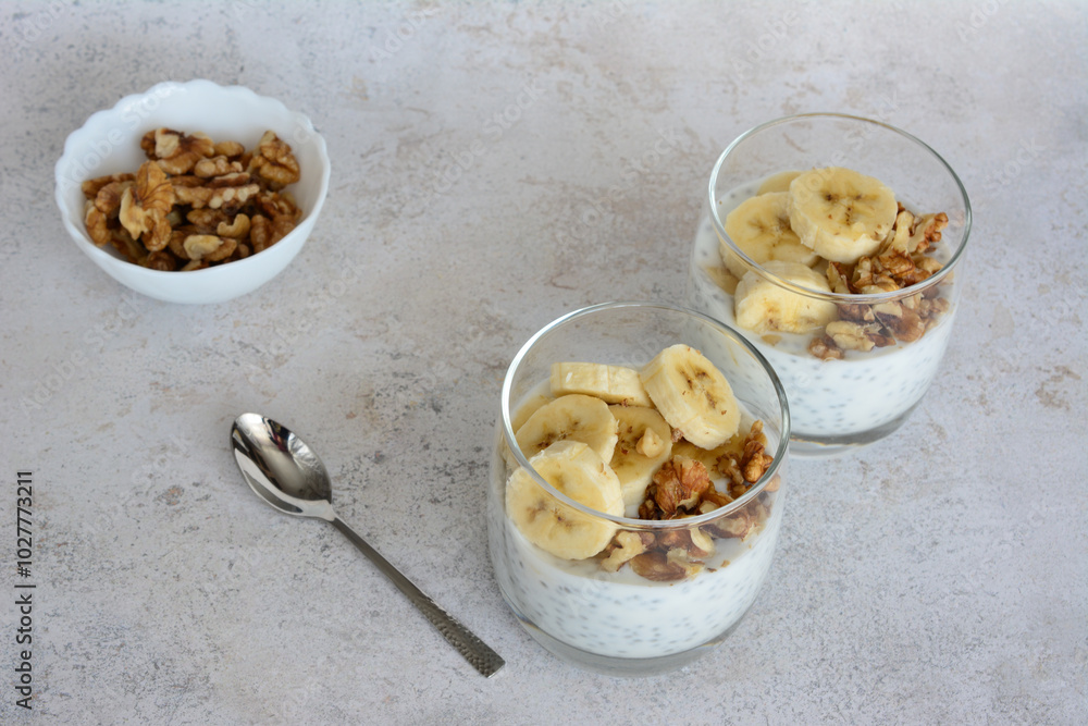 two glasses of chia pudding with cereal, bananas and walnut two glasses of chia pudding with cereal, bananas and walnut
