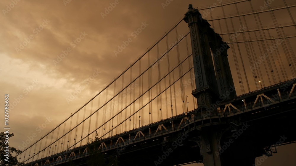 Fototapeta premium Manhattan Bridge to Brooklyn Dumbo. New York City symbol, USA travel destination. Architecture of United States of America, tourist landmark. Cables, evening sunset dramatic cloudy sky before rain.