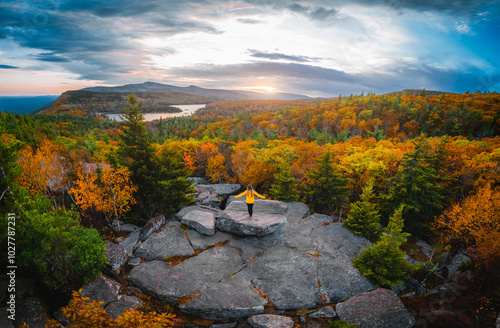 Epic Outdoor Freedom Inspiring Wide View on Female Hiker Adventure Travel Yellow Coat On Mountain Arms Up Autumn Colorful Forest Catskills New York