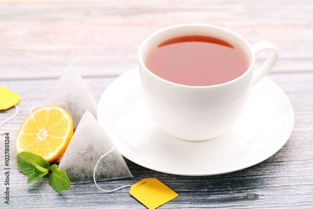 Cup of tea with lemon and mint leafs on wooden table Cup of tea with lemon and mint leafs on wooden table