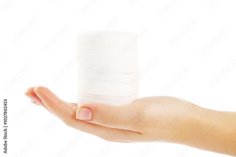 Stacked cotton pads in female hand isolated on white background