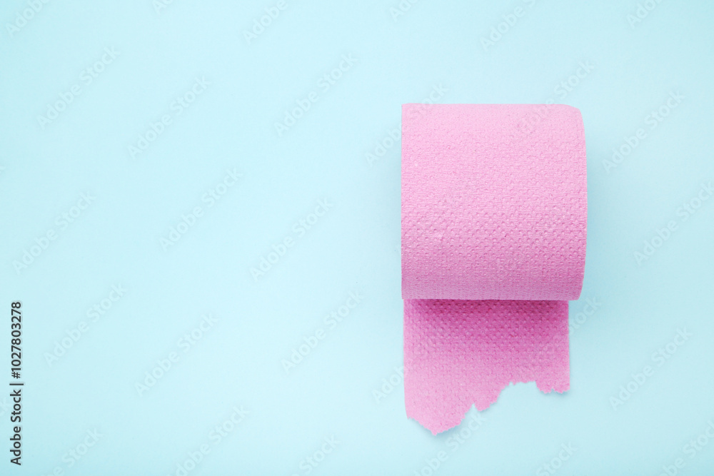 Pink roll of toilet paper on blue background Pink roll of toilet paper on blue background