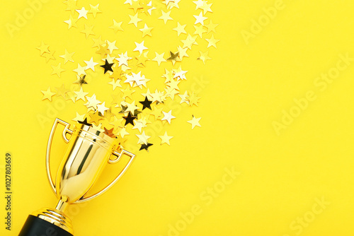 Obraz na płótnie Golden trophy cup with confetti on yellow background w salonie