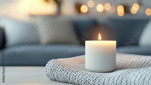 A lit candle on a textured cloth, creating a cozy atmosphere in a modern living room.