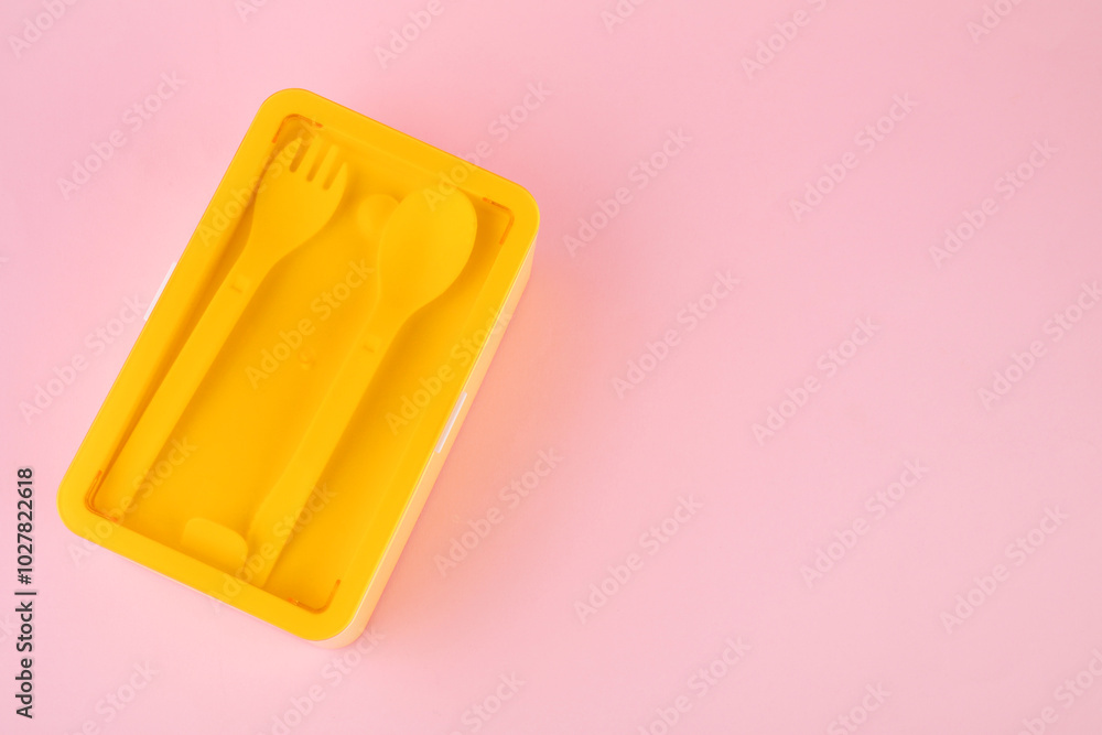 Plastic lunch box with cutlery on light pink background, top view. Space for text Plastic lunch box with cutlery on light pink background, top view. Space for text